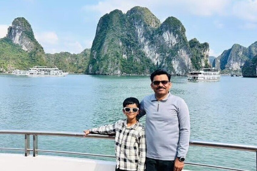 Two people on a boat with a view of limestone karsts and calm water. 1