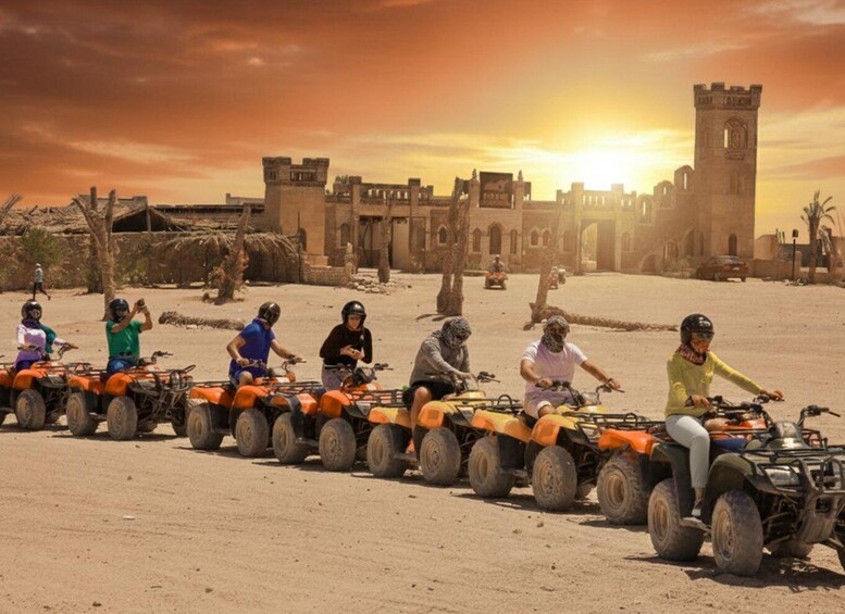 A group of people on quad bikes in a desert with ancient ruins in the background. 5