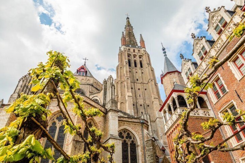 A historic church with a tall spire, intricate architecture, and ivy-covered walls. 1