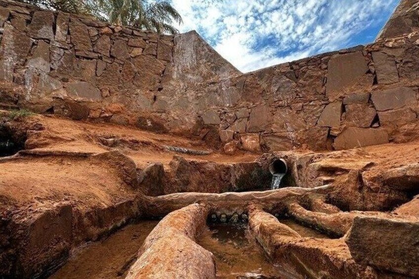 A dry, rocky landscape with a water channel flowing through it. 2