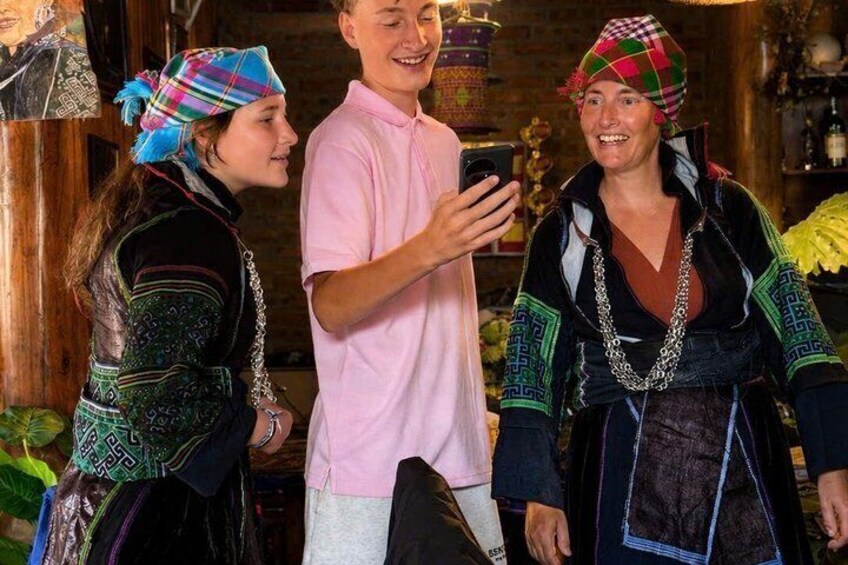 People in traditional attire, a wooden interior, and a person holding a smartphone. 5