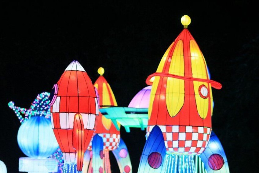 Colorful illuminated structures resembling rockets and a dome. 5