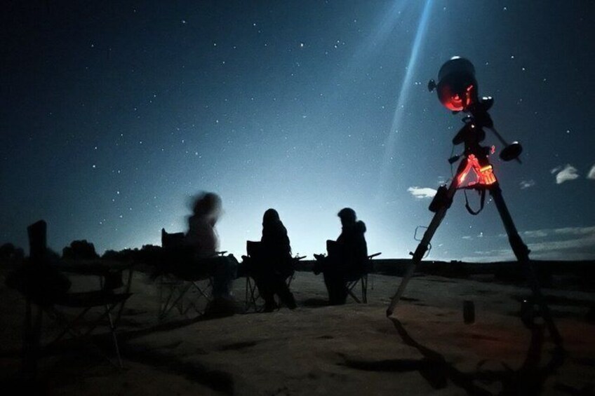A night sky with stars, a telescope, and people observing. 2