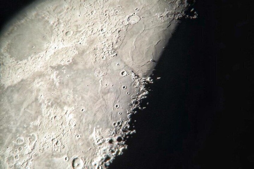 A lunar surface with craters and shadows. 3