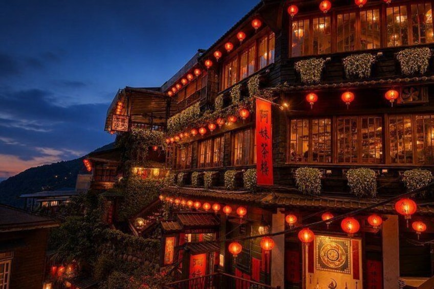 A traditional building with multiple levels, adorned with red lanterns and a prominent red banner. 1