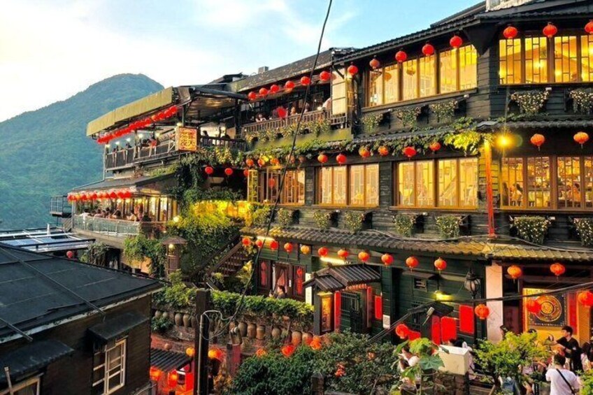 A traditional multi-story building with red lanterns, balconies, and greenery. 4