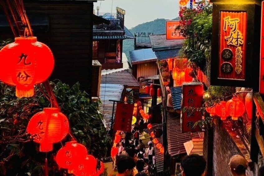 A narrow street with red lanterns and traditional Chinese architecture. 2
