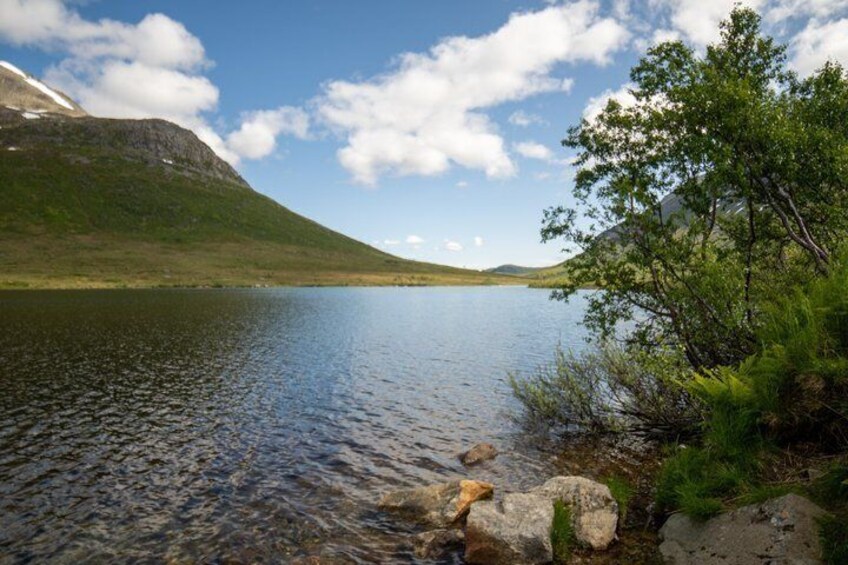 A calm lake surrounded by hills and greenery. 3