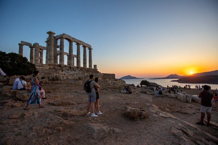 Ancient ruins, a sunset, and a beach with people. 1