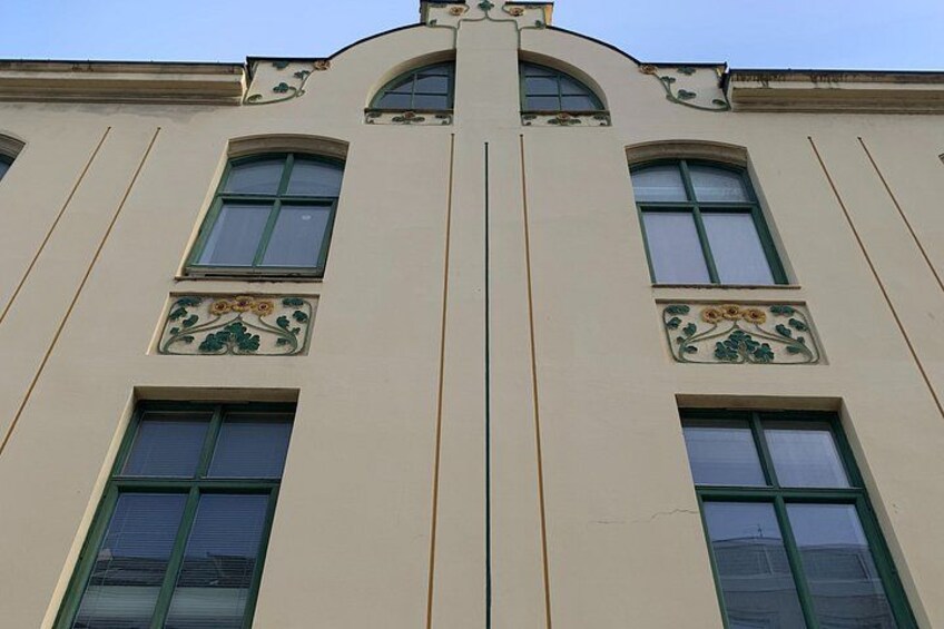 A building with a symmetrical facade, arched windows, and decorative floral patterns. 2