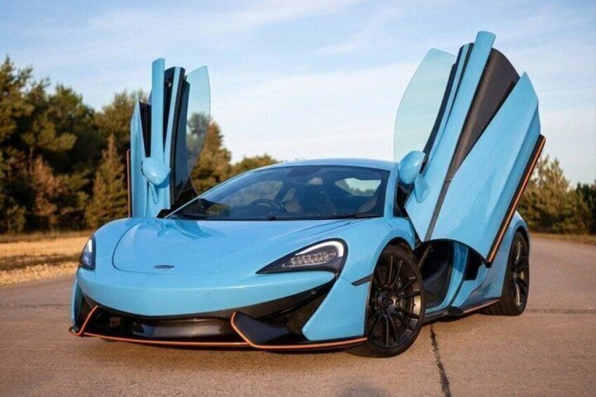 A blue sports car with open doors on a paved surface. 5