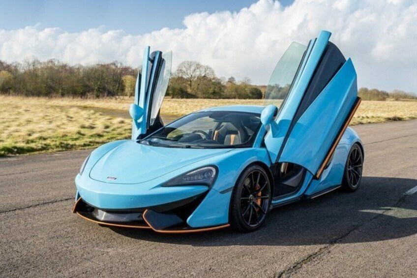 A blue sports car with its doors open on a road. 1