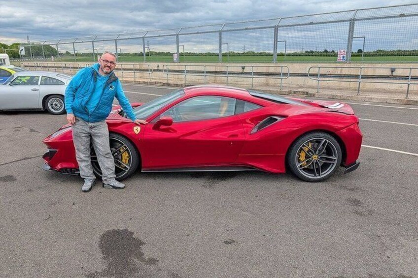 A red sports car with a damaged front bumper on a paved surface. 4