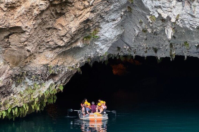 A cave entrance with a boat carrying people. 4