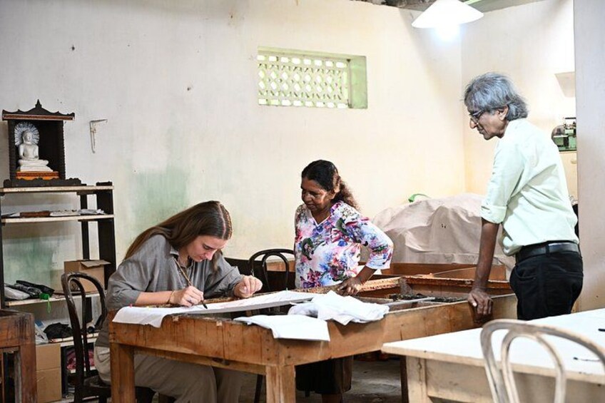 A classroom with students and a teacher. There are desks, chairs, and a statue on a shelf. 2