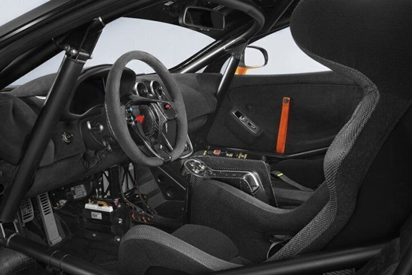 A car's interior with a steering wheel, dashboard, and seats. 5