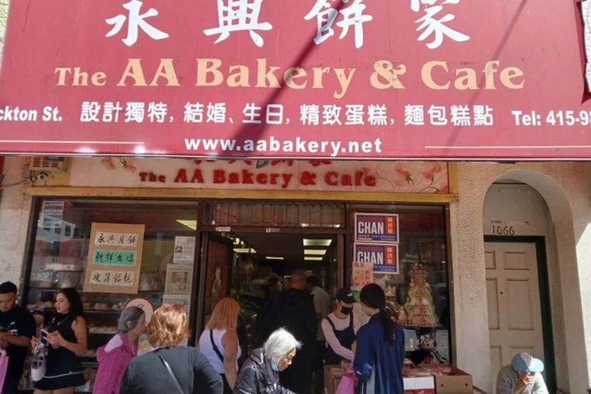 The AA Bakery & Cafe storefront with people outside. 2