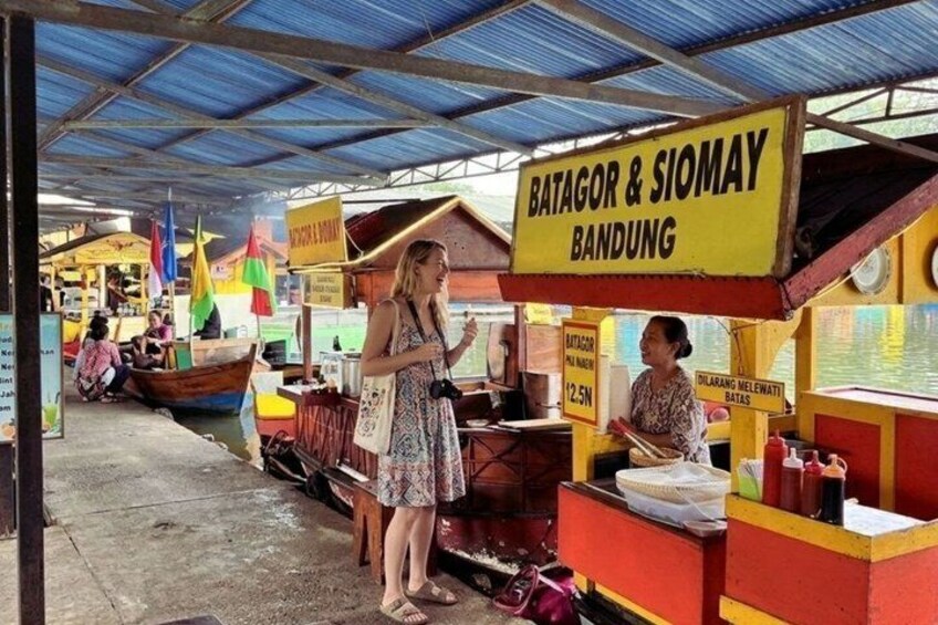 A market with a sign reading 'BATAGOR & SIOMAY BANDUNG' and a boat in the background. 4