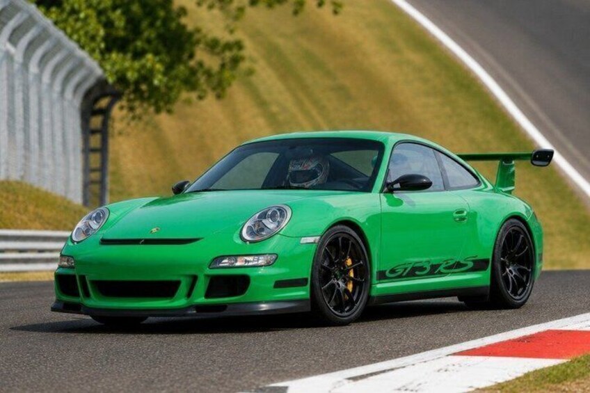 A green Porsche GT3 racing car on a race track. 2