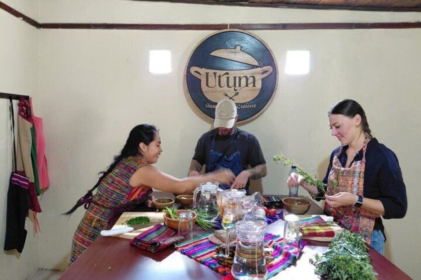 Three people preparing food at a table with various cooking utensils and ingredients. 1