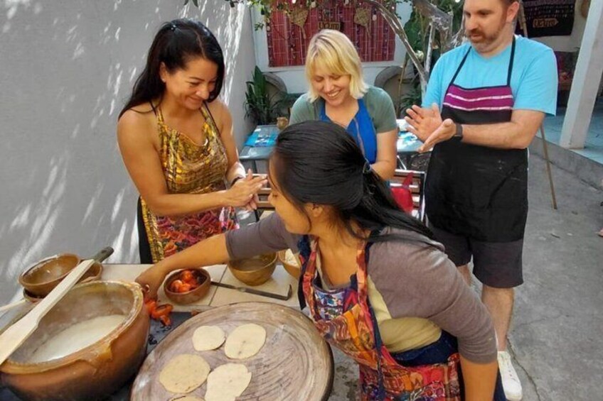 People preparing food outdoors with bowls, a wooden board, and cooking utensils. 4