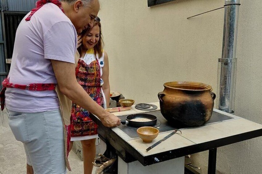 A person cooking outdoors with a large pot and a smaller pot on a table. 3
