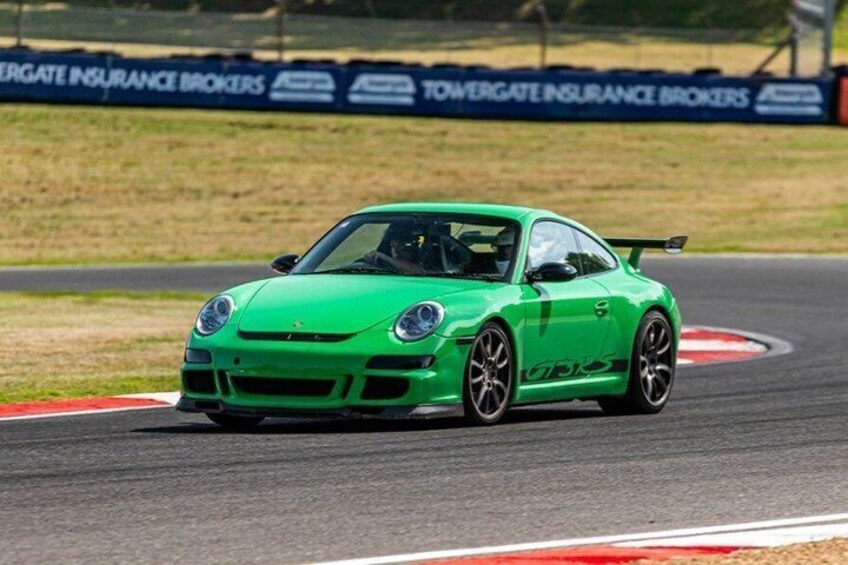 A green sports car on a race track. 1