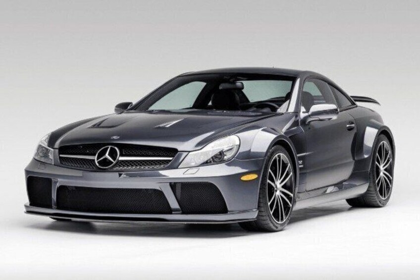 A gray Mercedes-Benz sports car with a black front grille, silver rims, and a sleek design. 4