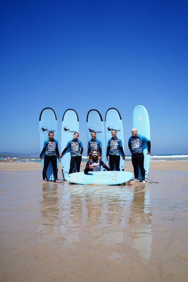 A group of people on a beach with surfboards. 4