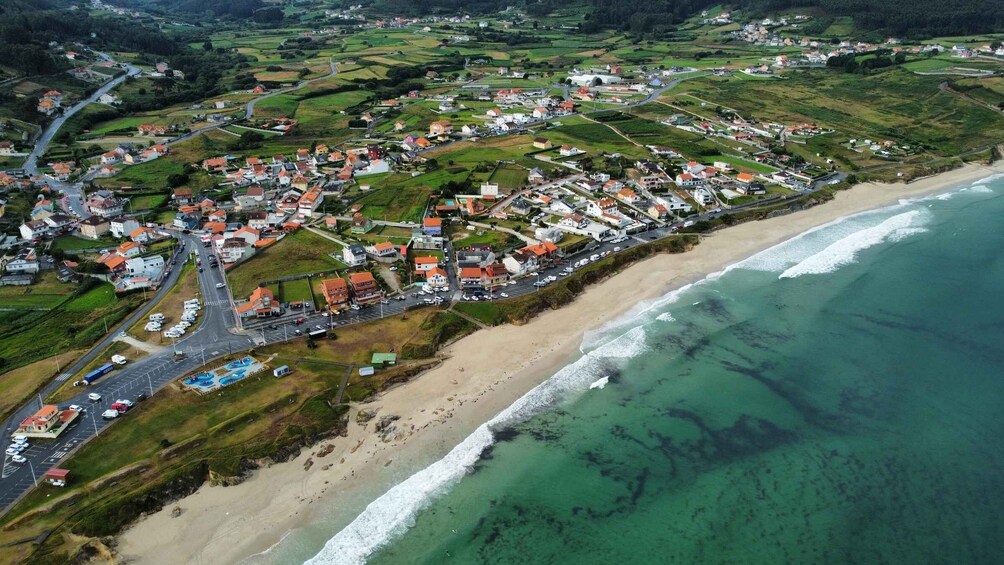 An aerial view of a coastal town with a beach, houses, and roads. 2