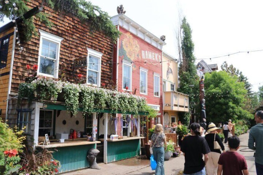A street with buildings, a green awning, and people walking. 5