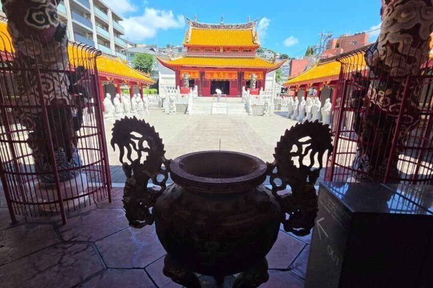 A traditional Chinese courtyard with ornate gates and a large bronze drum in the center. 5