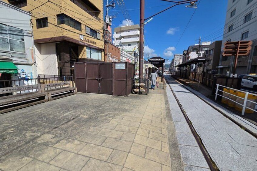 A street with buildings, a tram, and a pedestrian crossing. 4