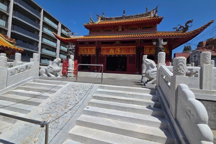 A traditional Chinese temple with ornate architecture, a stone bridge, and statues. 2