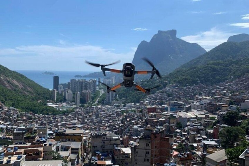 A drone flying over a densely populated city with a prominent mountain in the background. 1