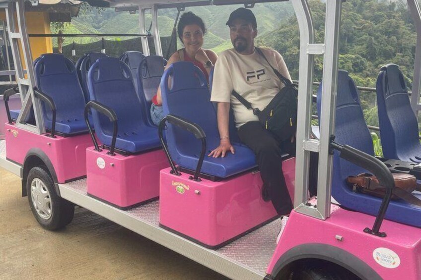 A pink and blue bus with passengers seated inside. 5