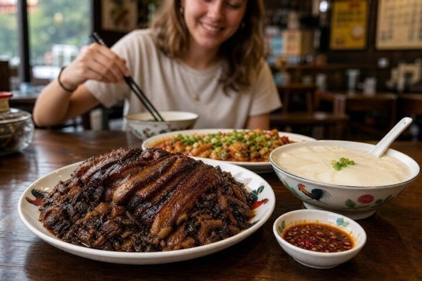 A person sitting at a table with a large plate of food, a bowl of soup, and a small bowl of sauce. 2