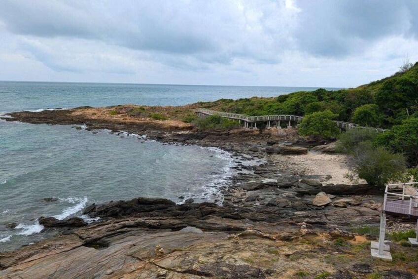 A rocky coastline with a wooden walkway and a bridge. 5