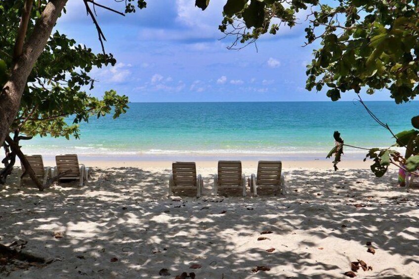 A beach with lounge chairs and a clear view of the ocean. 2