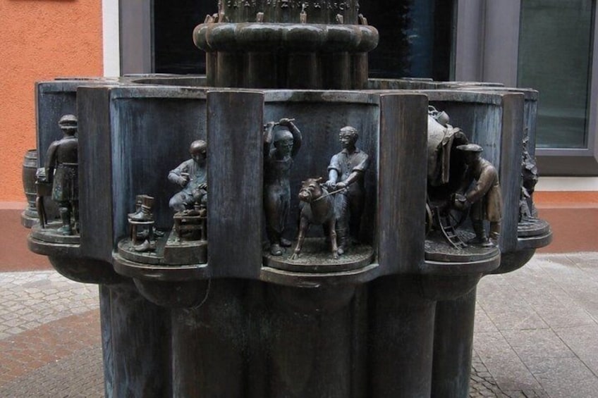 A bronze sculpture of people in various activities. 5