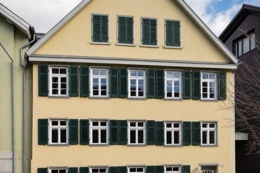 A multi-story building with green shutters and a yellow facade. 2