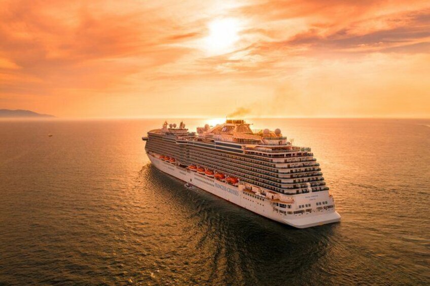A large cruise ship sailing on the ocean during sunset. 3