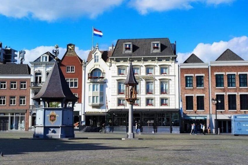 A town square with historic buildings, a flag, and a lamppost. 3