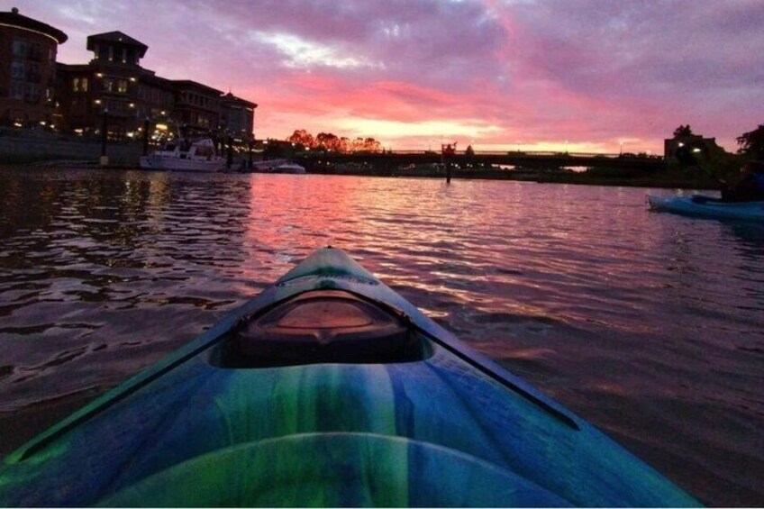 A kayak on calm water with a sunset in the background. 1