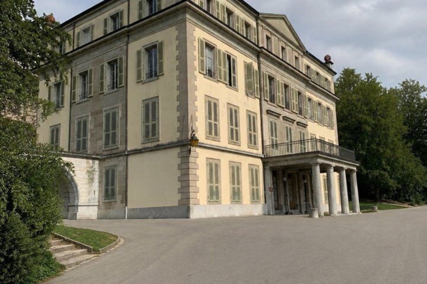 A large, multi-story building with a symmetrical facade, large windows, and a central entrance with columns. 3
