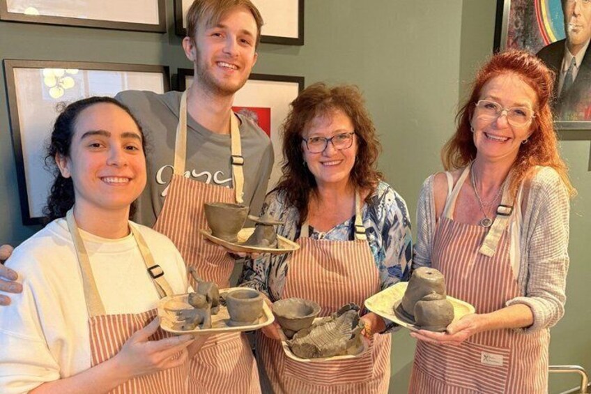 Four people holding pottery items. 4
