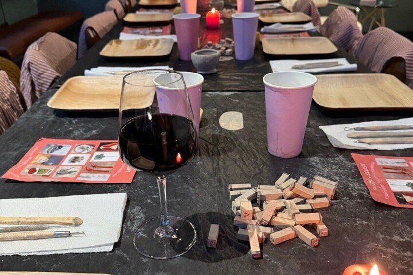 A table with a wine glass, wooden blocks, and placemats. 3