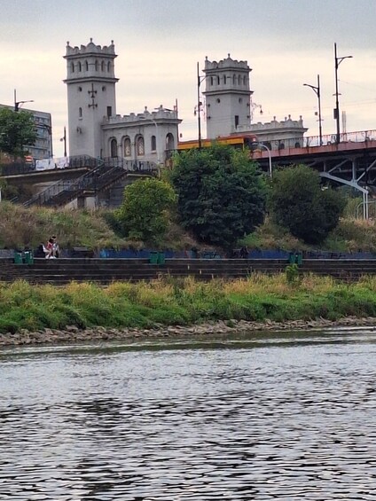 A river with a bridge and a castle-like building with towers. 1