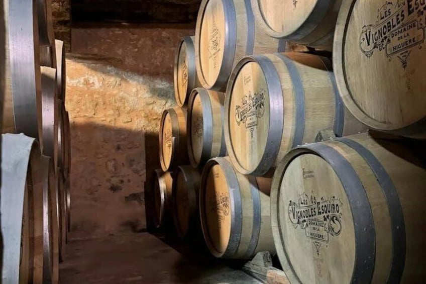 Wooden barrels stacked in a dimly lit cellar. 3