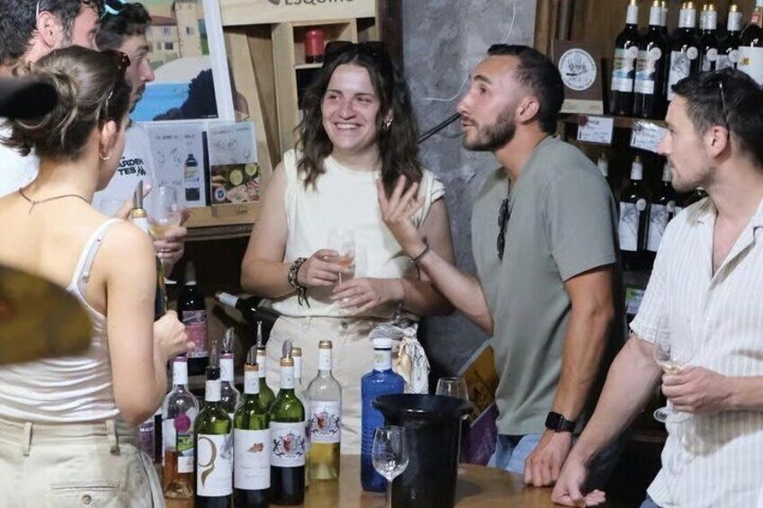 A group of people at a bar with bottles of wine and a pitcher. 4